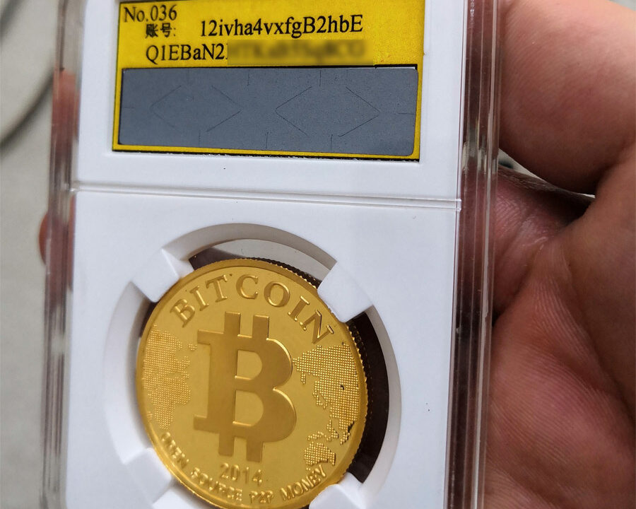 Gold bitcoin coin in a protective grading case