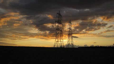 Electricity transmission pylons silhouetted at sunset over the US power grid