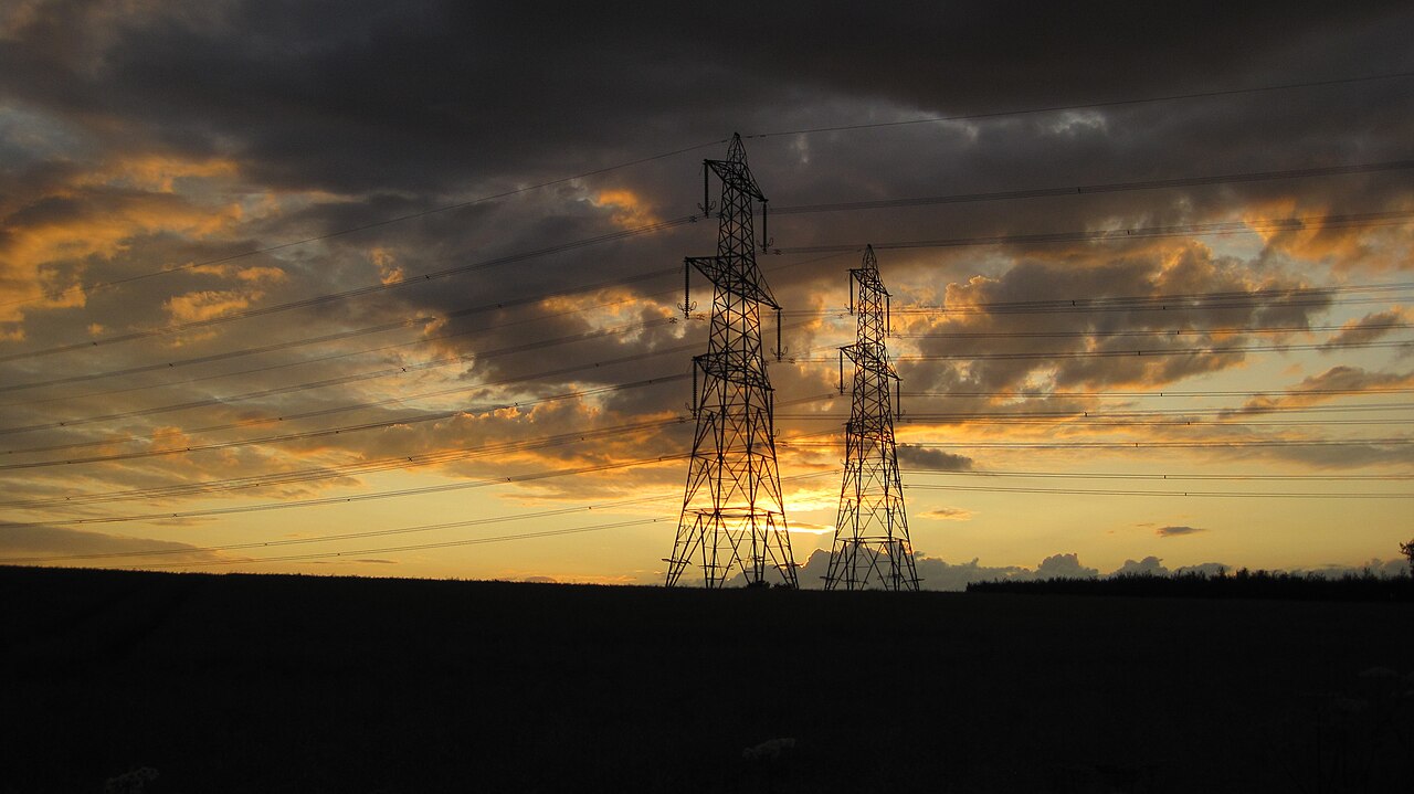 Electricity transmission pylons silhouetted at sunset over the US power grid